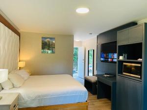 a bedroom with a bed and a desk with a tv at Hotel Civilia Lakeside by Civilia Golf Retreat in Clearwater