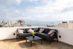a couch on a balcony with a view of the city at Entire Luxury Sliema Townhouse Steps from Beach in Sliema