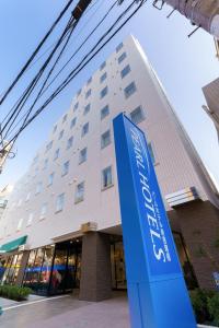 東京にあるパールホテル新宿曙橋の青い看板が目の前にある建物