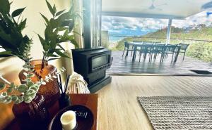 a living room with a television and a deck with a table at Shore Bird On Moreton in Tangalooma