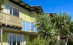 a building with palm trees in front of it at Shore Bird On Moreton in Tangalooma