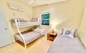a bedroom with two bunk beds and a window at Shore Bird On Moreton in Tangalooma