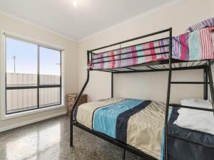 Un dormitorio con dos literas y una ventana. en Blue Door Retreat, en Edithburgh