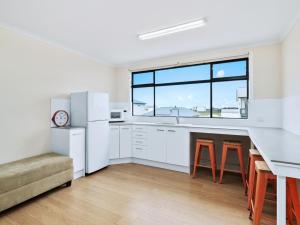 cocina con electrodomésticos blancos y ventana grande en Blue Door Retreat, en Edithburgh