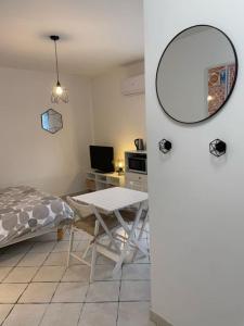 een kamer met een tafel en een bed en een tafel en een spiegel bij T1 Centre ville Carré d'or parking gratuit in Ajaccio