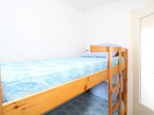 um beliche num quarto com piso azul em Appartement Argelès-sur-Mer, 2 pièces, 4 personnes - FR-1-309-255 em Argelès-sur-Mer