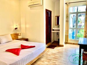 a bedroom with a bed with red pillows on it at Garden Village Guesthouse & Pool Bar in Siem Reap