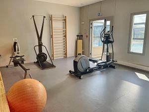 un gimnasio con varios equipos de ejercicio en una habitación en Mobil-Home Jullouville, 3 pièces, 4 personnes - FR-1-361A-2 en Jullouville-les-Pins