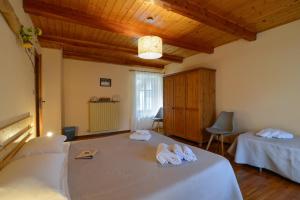 Habitación con 2 camas y toallas. en Bed & Breakfast Ai Fontana, en Villar Pellice