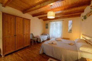 sypialnia z 2 łóżkami i drewnianym sufitem w obiekcie Bed & Breakfast Ai Fontana w mieście Villar Pellice