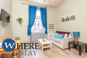 a living room with blue curtains and a couch at Leith Walk 1 bedroom Apartment in Edinburgh