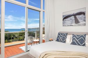 a bedroom with a bed and a large window at Ubuntu by Experience Jervis Bay in Vincentia