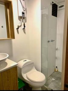 a bathroom with a toilet and a glass shower at Cama Queen, Vista a las Montañas in Manizales