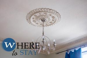 a chandelier hanging from a ceiling with the words here to stay at Leith Walk 1 bedroom Apartment in Edinburgh