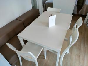 - Sala de estar con mesa blanca y 2 sillas en Garda Di Vino Agricamping & Wine Shop Lazise en Ronchi