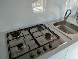 a stove top oven sitting next to a sink at Garda Di Vino Agricamping & Wine Shop Lazise in Ronchi