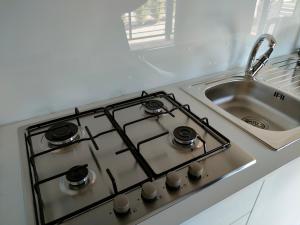 un four avec plaques de cuisson installé à côté d'un évier dans l'établissement Garda Di Vino Agricamping & Wine Shop Lazise, à Ronchi