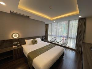a bedroom with a large bed and a large window at 3T Hotel Hanoi in Hanoi
