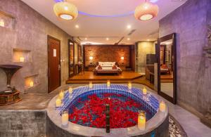 Cambana d'Angkor Suites في سيام ريب: غرفة مع حوض كبير مليء بالورود الحمراء