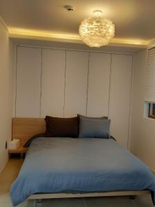 um quarto com uma cama grande e um lustre em Pool Story 6 em Jeju