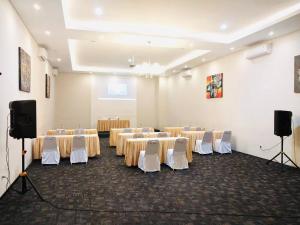 a conference room with tables and chairs and speakers at Kuta Majesty Hotel in Legian