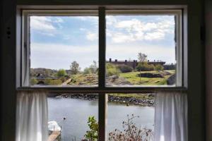 a window with a view of a body of water at Seaside Cottage in Suomenlinna in Helsinki
