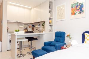 1 dormitorio con sillas azules, escritorio y cama en Ocean Top Marina en Yeosu