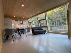 ein Wohnzimmer mit einem Sofa, einem Tisch und Stühlen in der Unterkunft Mondholz - Urban Inn 24-7 in Innsbruck