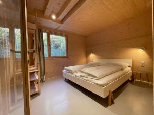- une chambre avec un lit dans une maison en bois dans l'établissement Mondholz - Urban Inn 24-7, à Innsbruck