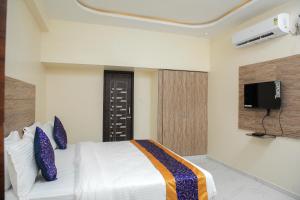 - une chambre avec un lit et une télévision murale dans l'établissement Redstone Service Apartment-TNagar Near USConsulate, à Chennai