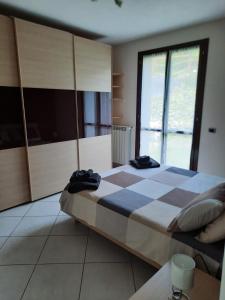 een slaapkamer met een groot bed en een groot raam bij Holiday home Tavullia in Tavullia