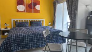 Un dormitorio con una cama y una mesa y una ventana. en KARON STUDIO APARTMENT, en Karon Beach