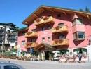 a pink building with flowers on the windows of it at Bilocale Campo in Madonna di Campiglio