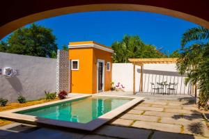 uma casa com uma piscina ao lado de um pátio em Casa Flamingos Altabi em Mérida