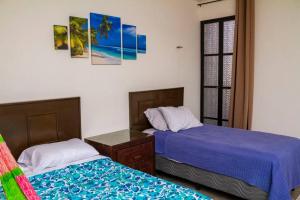 duas camas sentadas uma ao lado da outra num quarto em Casa Flamingos Altabi em Mérida