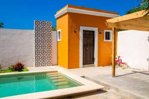 uma casa com piscina em frente a uma casa em Casa Flamingos Altabi em Mérida