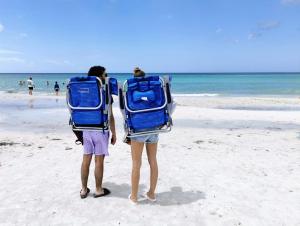 two people standing on the beach with back packs at Luxury 3BD house, Siesta Key Beach in Sarasota