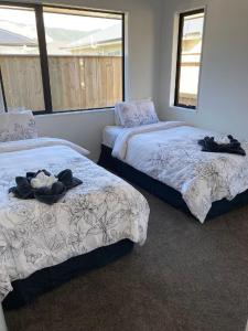 ein Schlafzimmer mit 2 Betten und Handtüchern darauf in der Unterkunft Brand new family home in Richmond