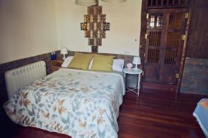 a bedroom with a bed and a table and a door at Amumamaria_ vt in Bermeo