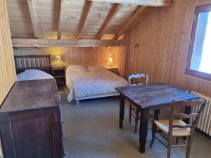 a bedroom with two beds and a table in a room at Grand chalet 11 pers, 4 chambres, Sud, proche ski - FR-1-733-72 in Crest-Voland