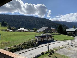 a building on a road with a mountain in the background at Duplex 6 pers, proche pistes, casier à skis, parking - FR-1-733-81 in Crest-Voland