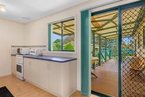a kitchen with white cabinets and a large window at Pascalinga 38 Carrickalinga Road in Carrickalinga