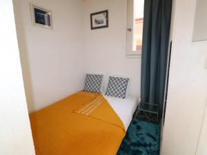 ein kleines Schlafzimmer mit einem Bett in einem Zimmer in der Unterkunft Appartement Le Grau-du-Roi, 2 pièces, 4 personnes - FR-1-307-240 in Le Grau-du-Roi