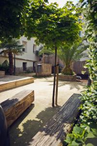 a park with two wooden benches and a tree at Amumamaria_ vt in Bermeo