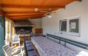 a bedroom with a bed and two chairs and a fireplace at Holiday Home Skabrnja 79 With Outdoor Swimmingpool in Galovac