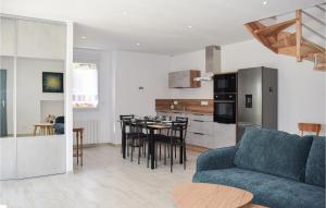 a living room with a blue couch and a kitchen at Awesome Home In Canihuel in Canihuel