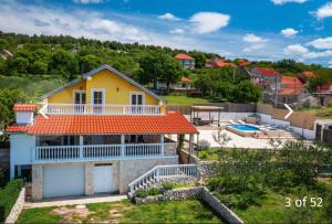uma casa amarela com um telhado laranja e um quintal em Agro casa em Skradin