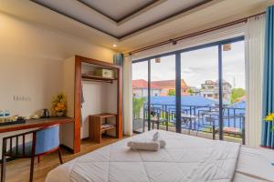 ein Schlafzimmer mit einem Bett und einem Balkon in der Unterkunft Angkor Rithy Residence 2 in Phumĭ Réach Born (1)