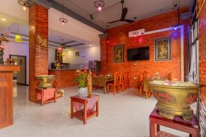 a room with a brick wall and a dining room at Angkor Rithy Residence 2 in Phumĭ Réach Born (1)