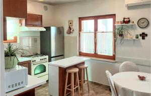 a kitchen with a refrigerator and a table with chairs at Stunning Home In Gornje Selo With Outdoor Swimming Pool in Gornje Selo